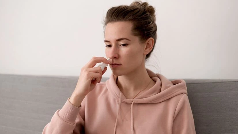 Девушка капает в нос капли